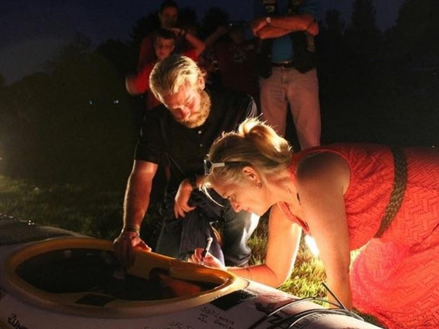 Gold Star mom, Debbie Lee, signing the kayak for the Swim for the Sacrifice challenge